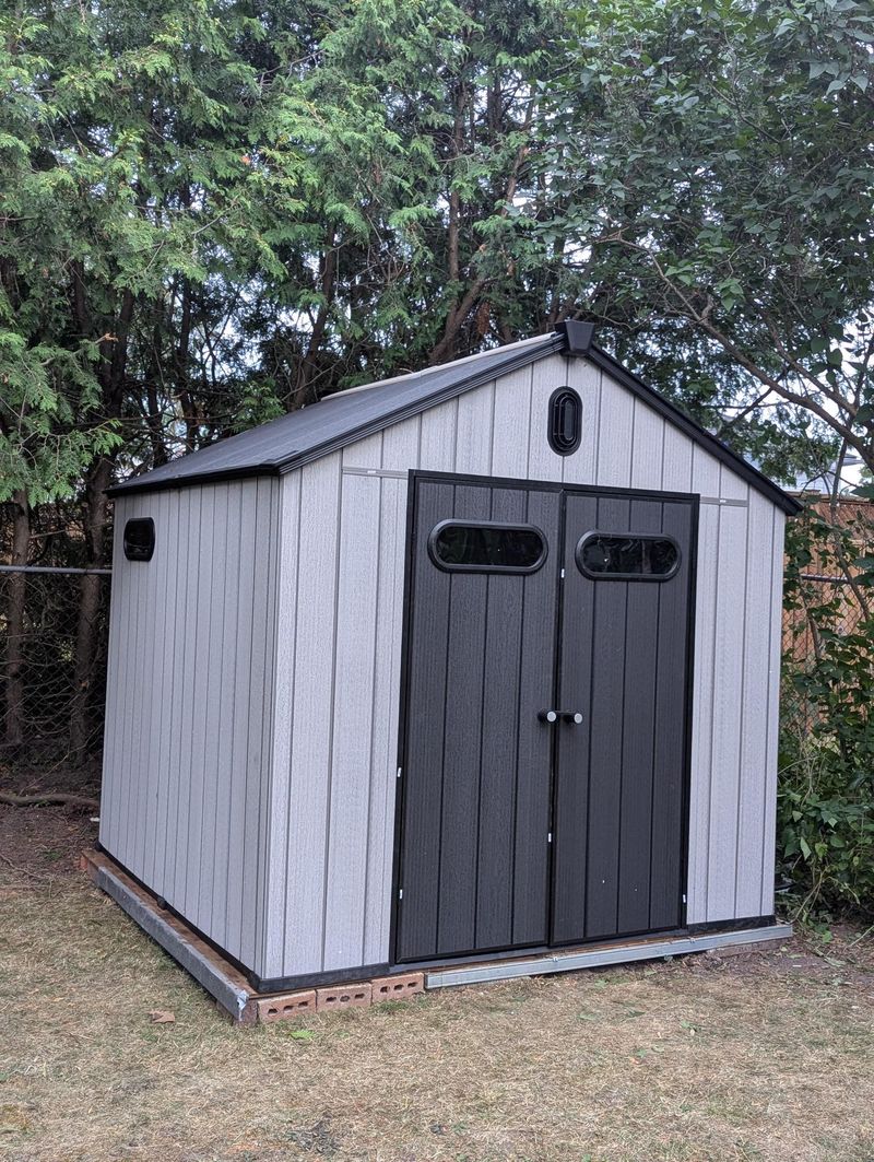 8x8 resin shed installed in Belleville backyard with trees