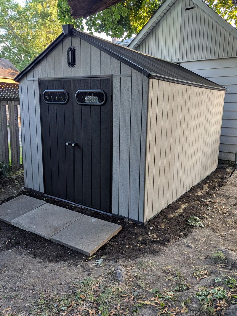 Resin shed side angle view installed next to house in Belleville Ontario